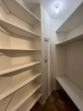 a view of walk in closet with empty racks
