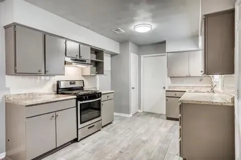 a kitchen with stainless steel appliances granite countertop a stove and a sink