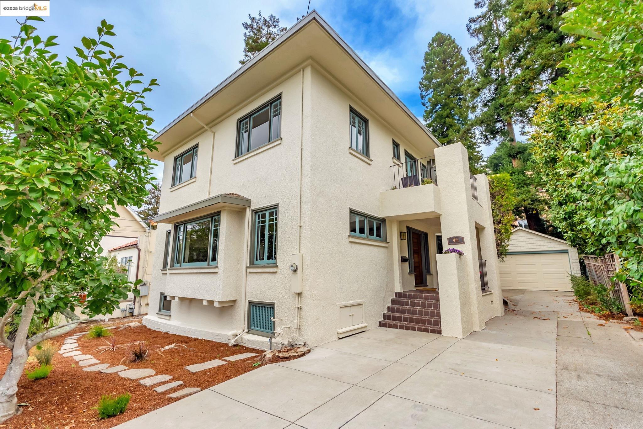 971 Santa Barbara Road Berkeley, CA 94707 - Photo 26 of 37 a view of a white house with a small yard and large tree