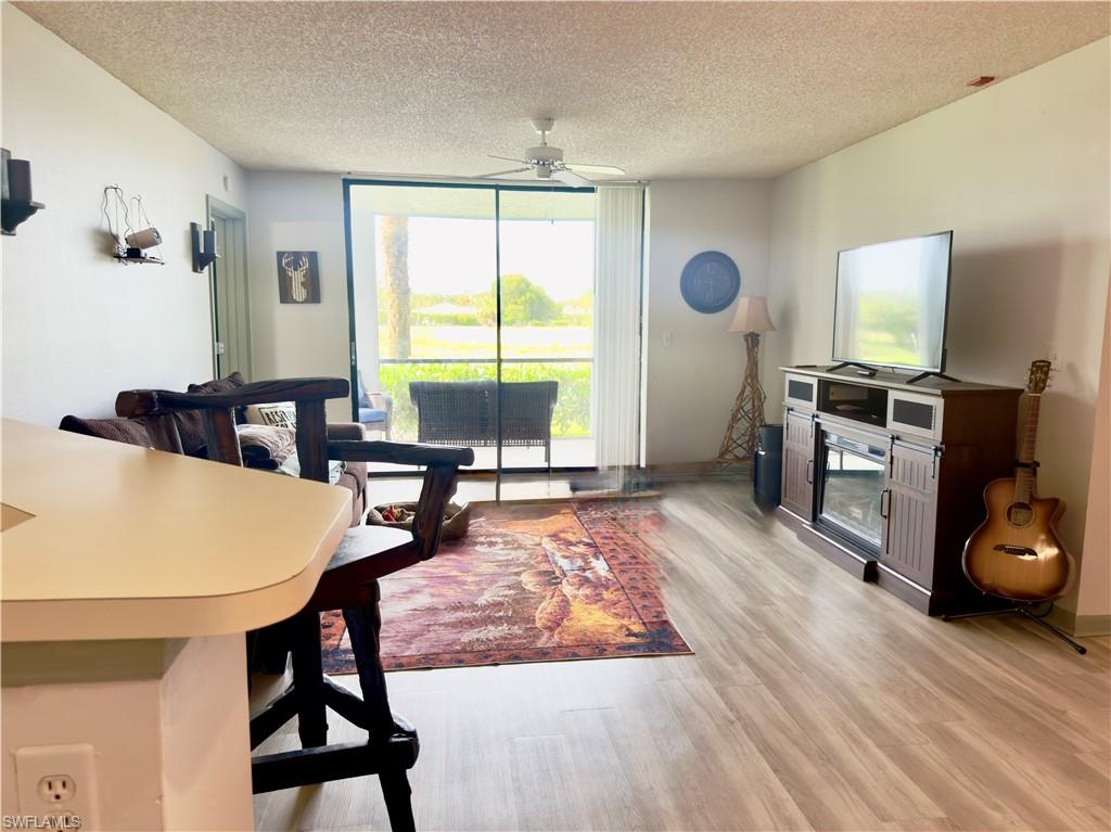 13615 Eagle Ridge Drive, Unit 1614 Fort Myers, FL 33912 - Photo 27 of 34 Spacious recreation room featuring multiple windows, recessed lighting, wall-mounted television screens, a full-wall mirror, and patterned carpet flooring
