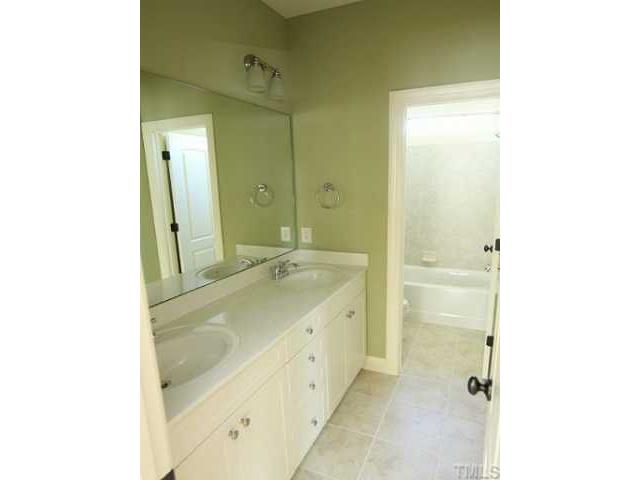 1327 Ileagnes Road Raleigh, NC 27603 - Photo 15 of 21 Second floor bathroom also has raised vanity with dual sinks, tile floor and tile surround. Plenty of space in this bathroom for two...