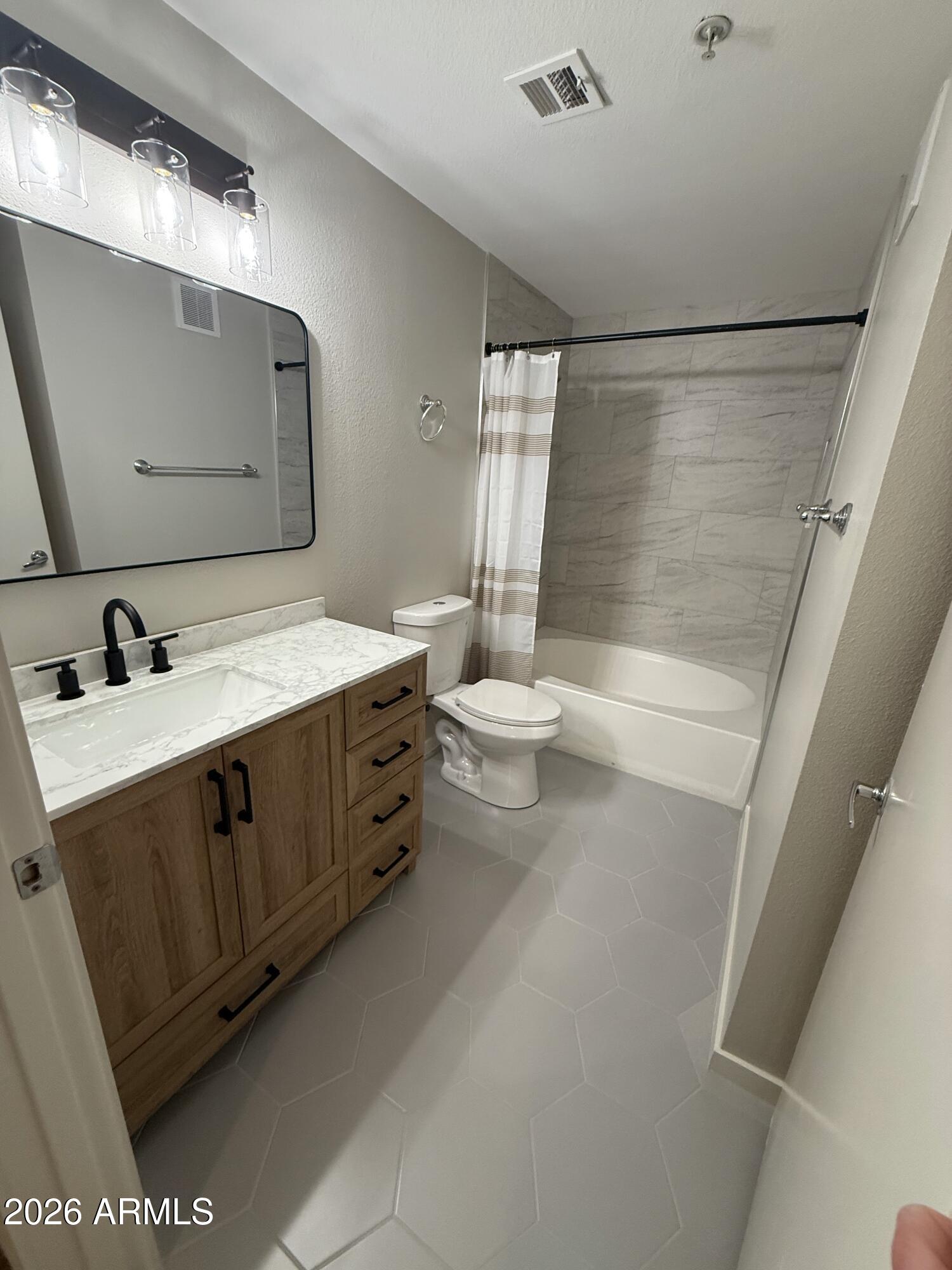 3633 North 3rd Avenue, Unit 1043 Phoenix, AZ 85013 - Photo 3 of 14 a bathroom with a double vanity sink toilet and mirror