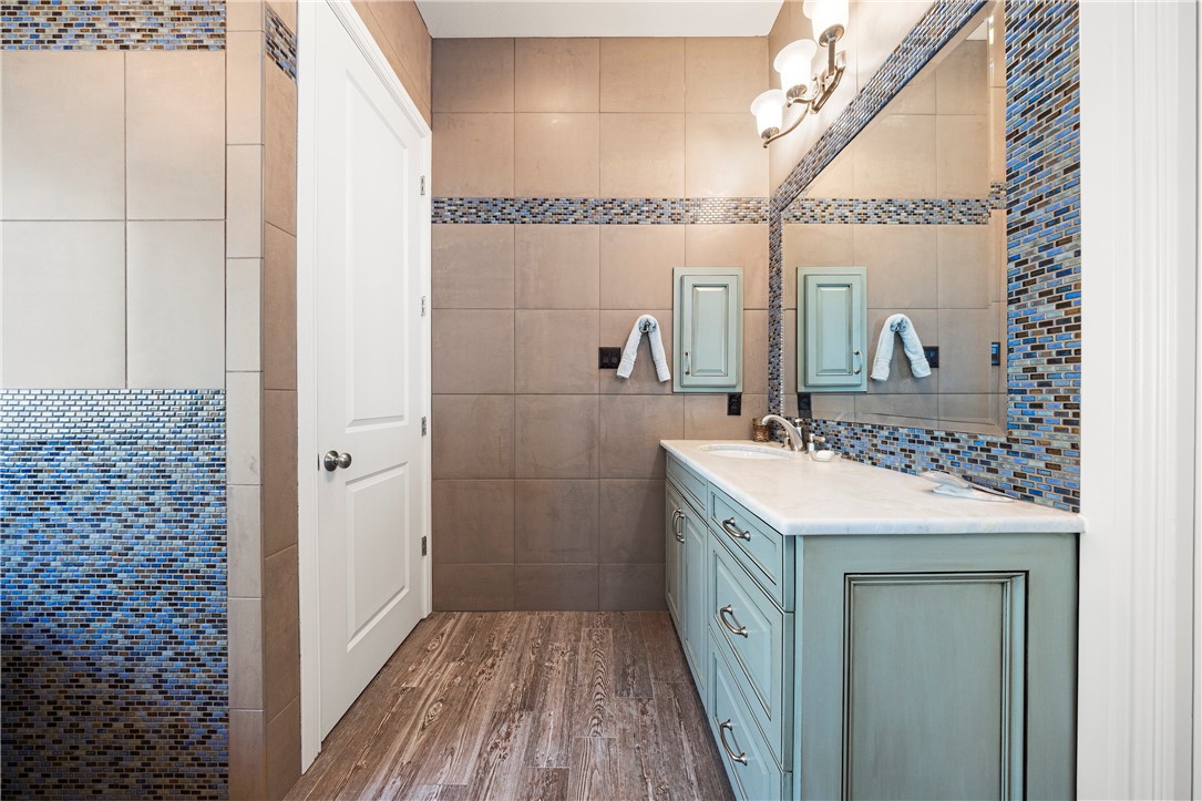 13806 Captains Row Corpus Christi, TX 78418 - Photo 17 of 40 a bathroom with a sink a mirror and a shower