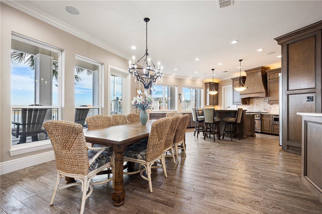 13806 Captains Row Corpus Christi, TX 78418 - Photo 6 of 40 a dining room with furniture a chandelier and wooden floor