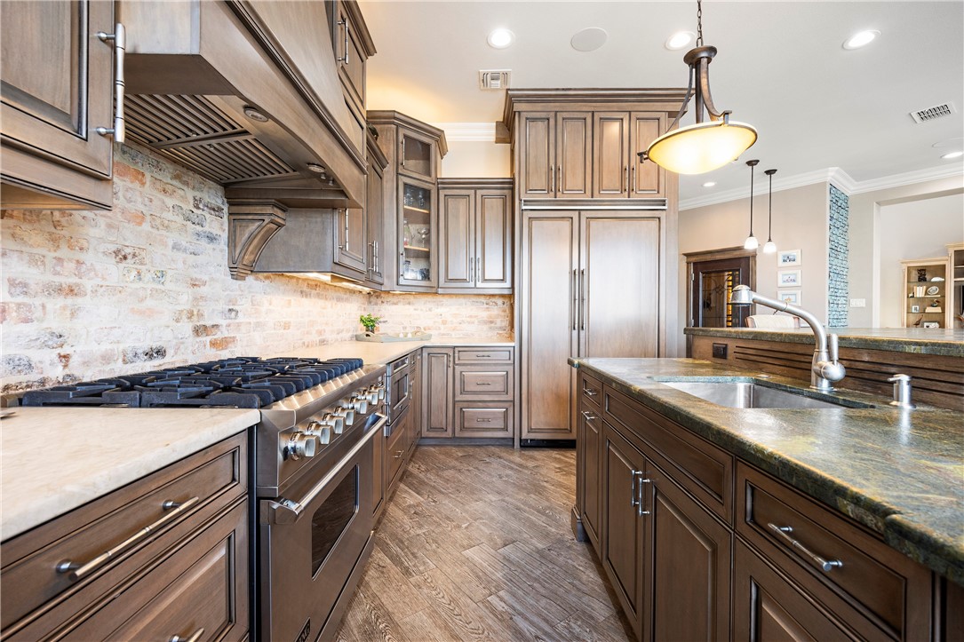 13806 Captains Row Corpus Christi, TX 78418 - Photo 9 of 40 a kitchen with stainless steel appliances granite countertop a sink a stove and a wooden floors