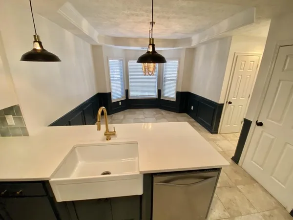a large kitchen with kitchen island granite countertop a sink a counter space and cabinets