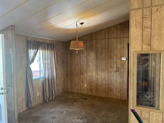an empty room with windows & cabinet