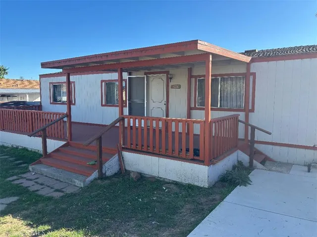 a view of a house with a yard and wooden fence
