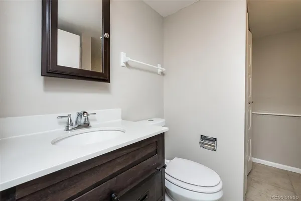 a bathroom with a sink vanity mirror and toilet