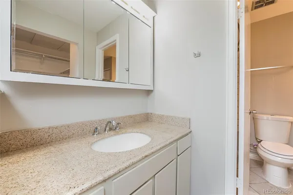 a bathroom with a granite countertop sink and a mirror