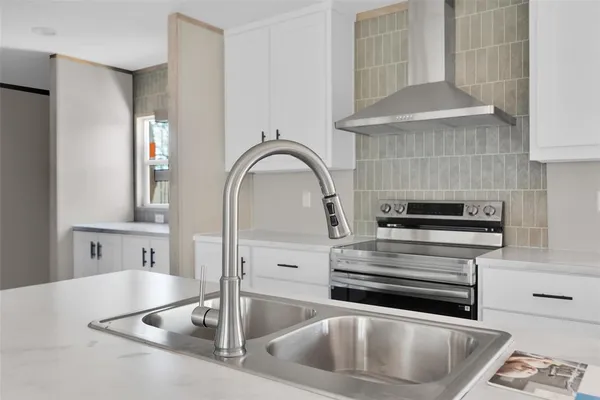 a kitchen with stainless steel appliances granite countertop a sink a stove and cabinets