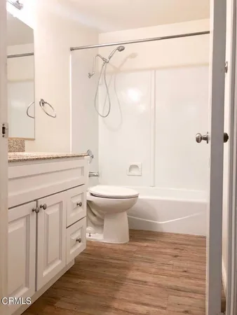 a bathroom with a granite countertop sink a toilet and shower