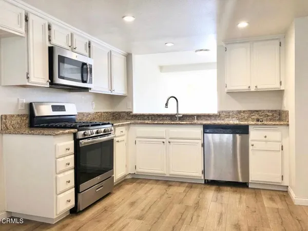 a kitchen with stainless steel appliances granite countertop a sink and a microwave