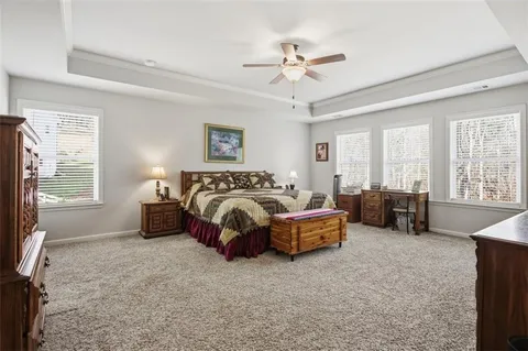 a spacious bedroom with a bed and glass door