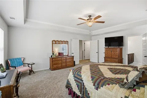 a bedroom with a bed dresser and a flat screen tv