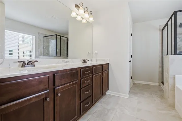 a spacious bathroom with a double vanity sink a large mirror and a shower