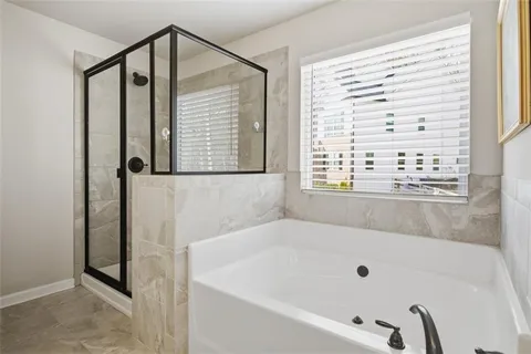 a bathroom with bathtub next to a window