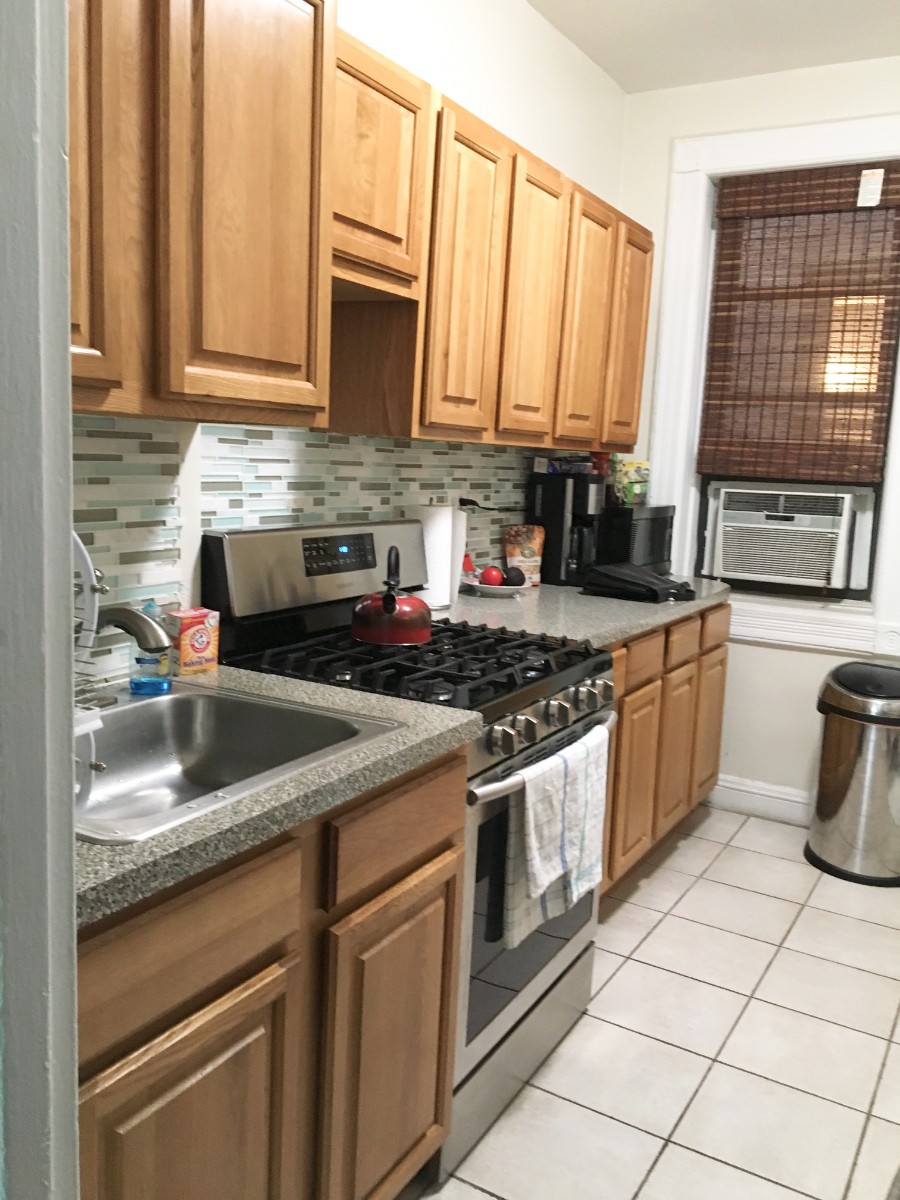 125 East 90th Street, Unit 3A Manhattan, NY 10128 - Photo 4 of 7 a kitchen with granite countertop a stove sink and cabinets