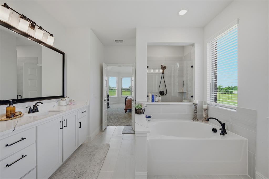 864 Shadow Valley Road Whitesboro, TX 76273 - Photo 25 of 40 Bathroom featuring a dual vanity with white cabinetry and dark hardware, a rectangular undermount sink, and a large framed mirror