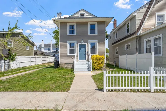 a front view of a house with a garden and plants