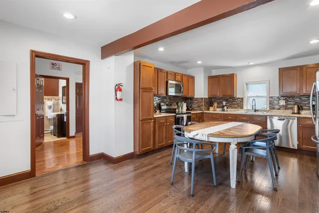 a dining room with stainless steel appliances a table and chairs