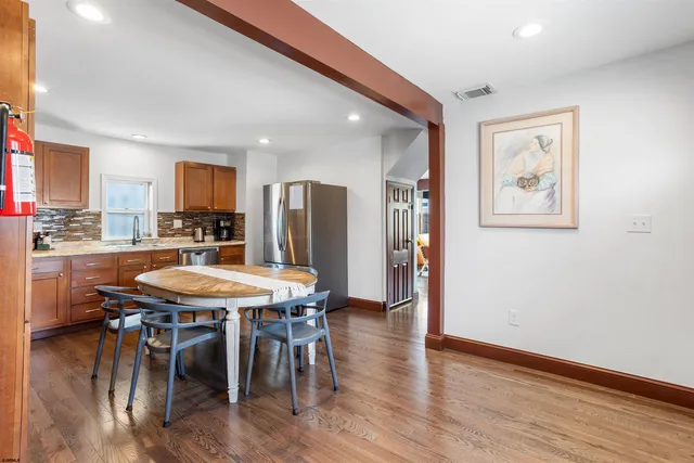 a dining room with a table chairs and a kitchen