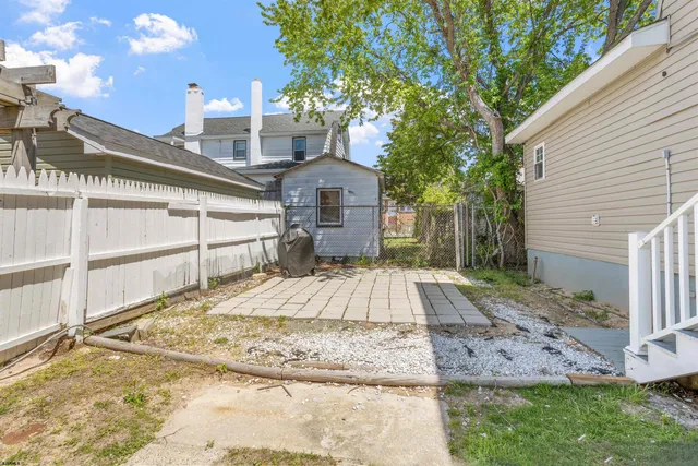 a view of a house with a yard and large tree