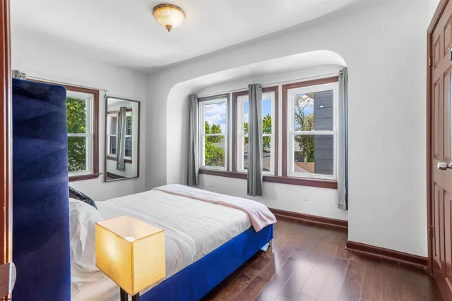 a bedroom with a bed and a lamp on dresser