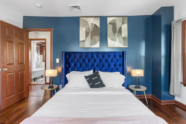 a bedroom with a bed and wooden floor