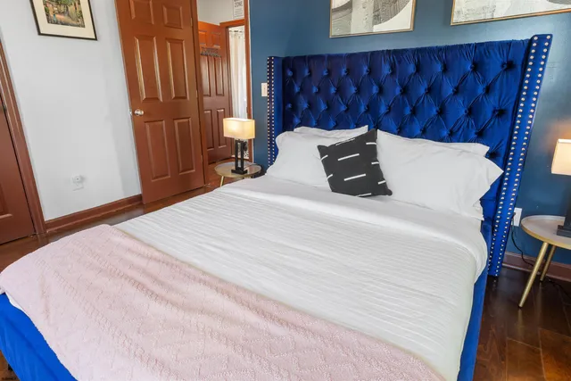 a bedroom with a bed and wooden floor