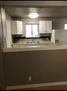 a view of a kitchen counter space a sink wooden floor and a window