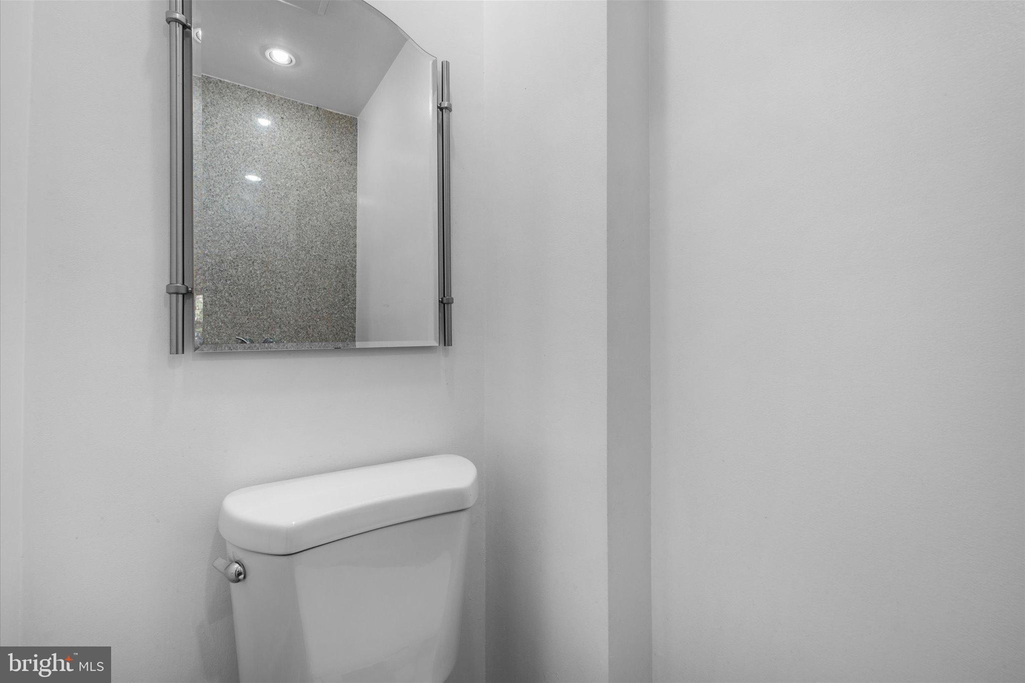 10276 Arizona Circle, Unit 61 Bethesda, MD 20817 - Photo 12 of 42 a bathroom with a sink a toilet and mirror