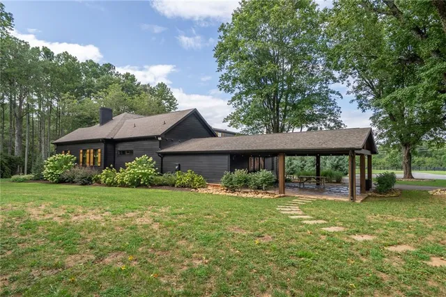 a view of a porch with a big yard potted plants and floor to ceiling window