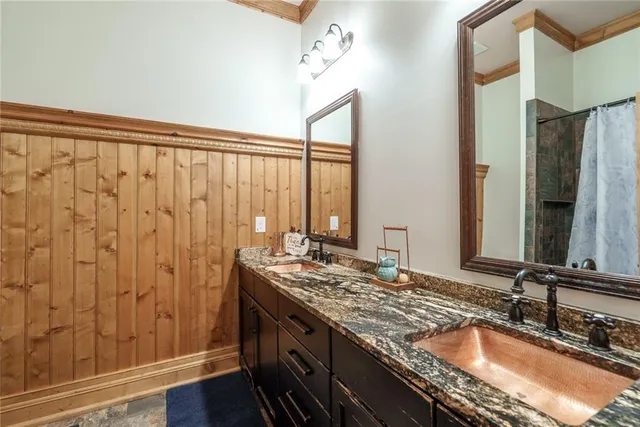 a bathroom with a granite countertop sink and a toilet