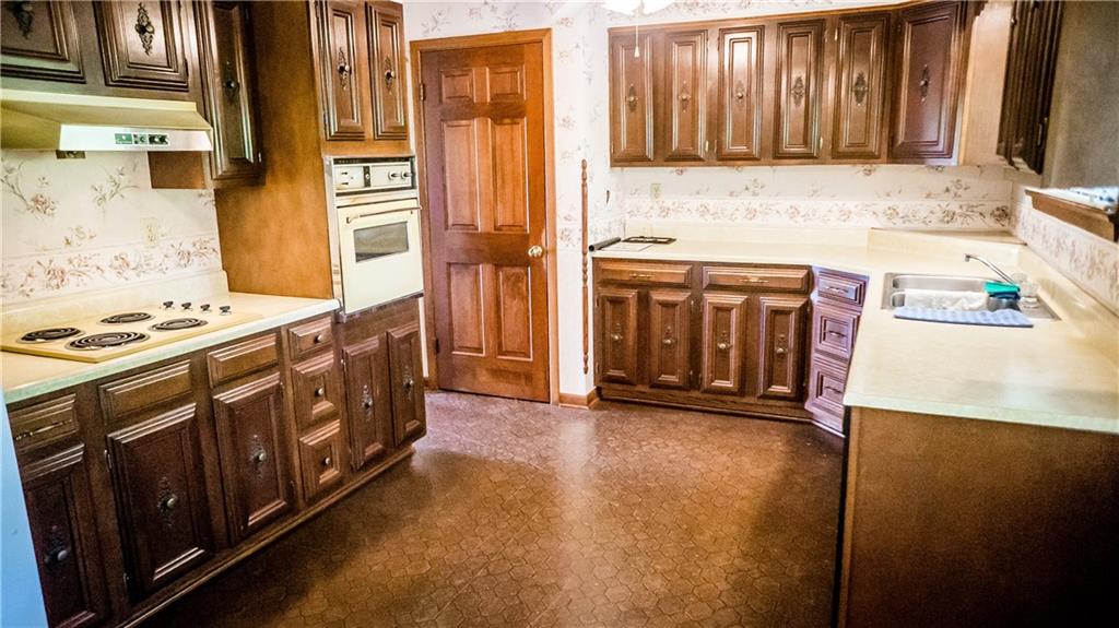 251 Welsh Road Valencia, PA 16059 - Photo 10 of 25 Wall to Wall Vinyl Flooring Accented by Dark Wood Cabinets and Cream colored Counter Tops