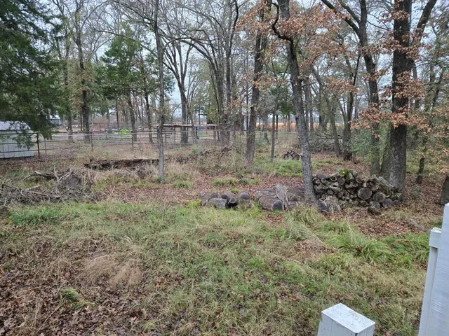 a backyard of a house with lots of green space and chair