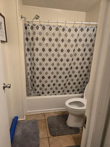 a bathroom with a toilet and a shower curtain