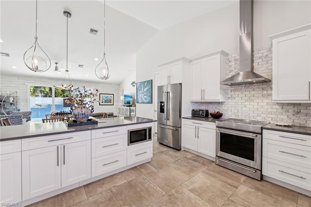 161 Tahiti Circle Naples, FL 34113 - Photo 11 of 42 a kitchen with white cabinets and white appliances