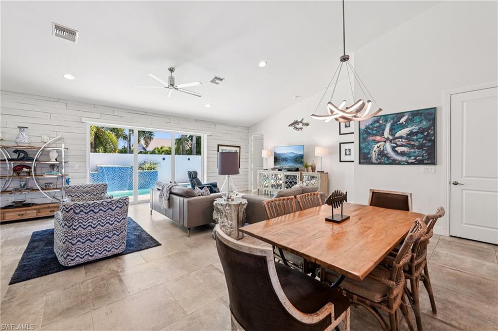 161 Tahiti Circle Naples, FL 34113 - Photo 13 of 42 Dining area featuring a chandelier, a ceiling fan, and lofted ceiling