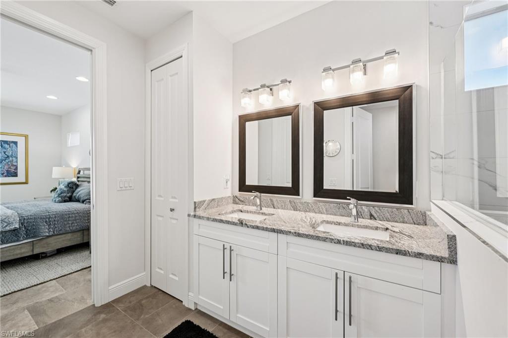 161 Tahiti Circle Naples, FL 34113 - Photo 25 of 42 a bathroom with double sink and a mirror