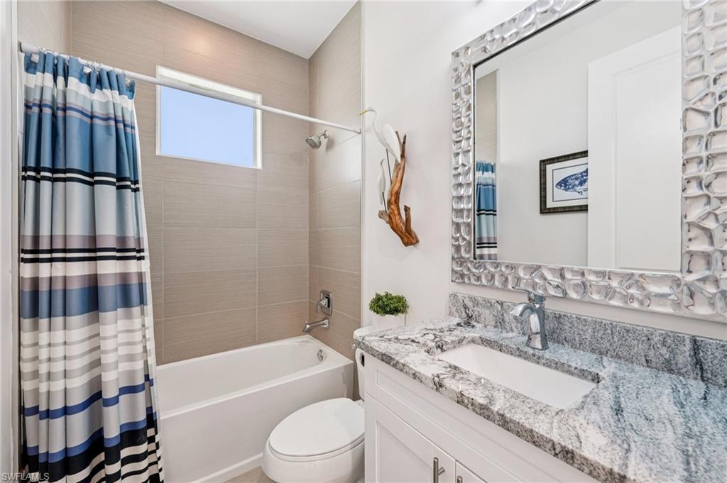 161 Tahiti Circle Naples, FL 34113 - Photo 29 of 42 a bathroom with a granite countertop bathtub sink vanity mirror and toilet