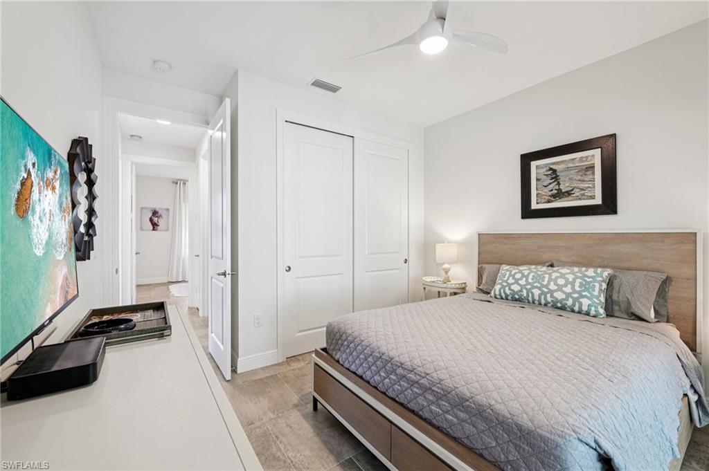 161 Tahiti Circle Naples, FL 34113 - Photo 30 of 42 a bedroom with a bed and a chandelier