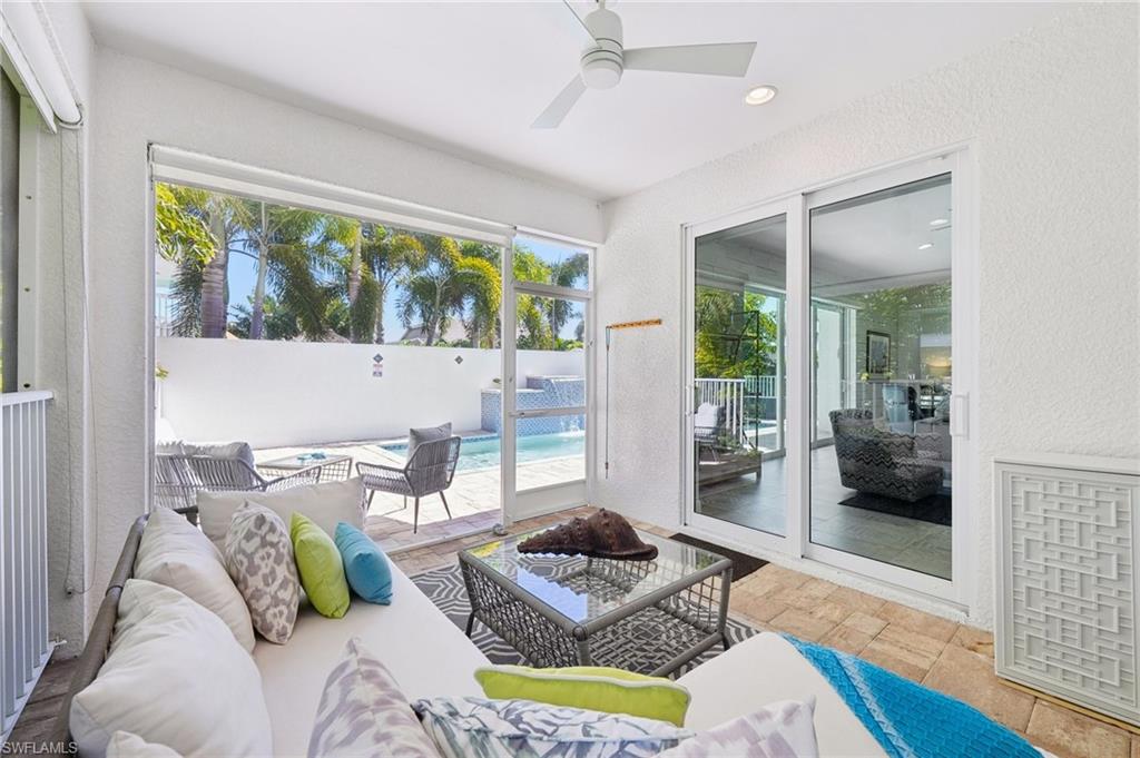 161 Tahiti Circle Naples, FL 34113 - Photo 33 of 42 a living room with furniture and a floor to ceiling window