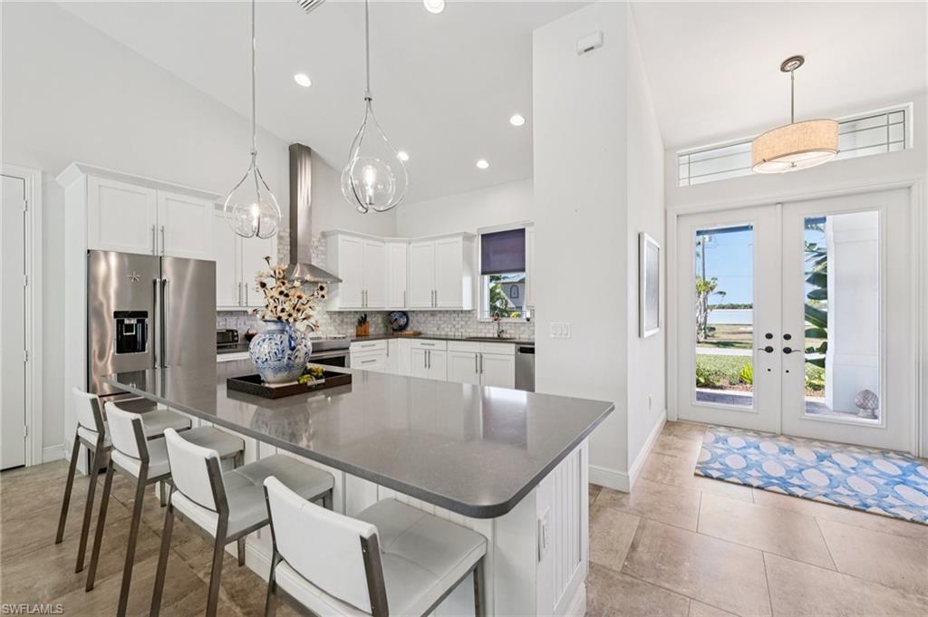 161 Tahiti Circle Naples, FL 34113 - Photo 8 of 42 a kitchen with a table chairs refrigerator and microwave