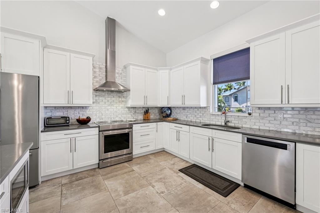161 Tahiti Circle Naples, FL 34113 - Photo 9 of 42 a kitchen with stainless steel appliances granite countertop a stove sink and cabinets