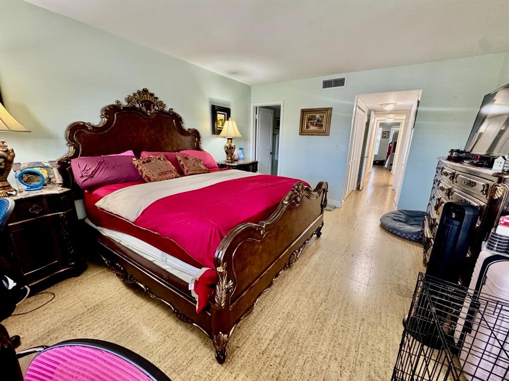 800 East Camino Real, Unit PH4160 Boca Raton, FL 33432 - Photo 17 of 22 a bedroom with a bed and wooden floor