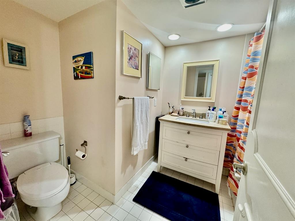 800 East Camino Real, Unit PH4160 Boca Raton, FL 33432 - Photo 19 of 22 a bathroom with a sink toilet vanity and mirror