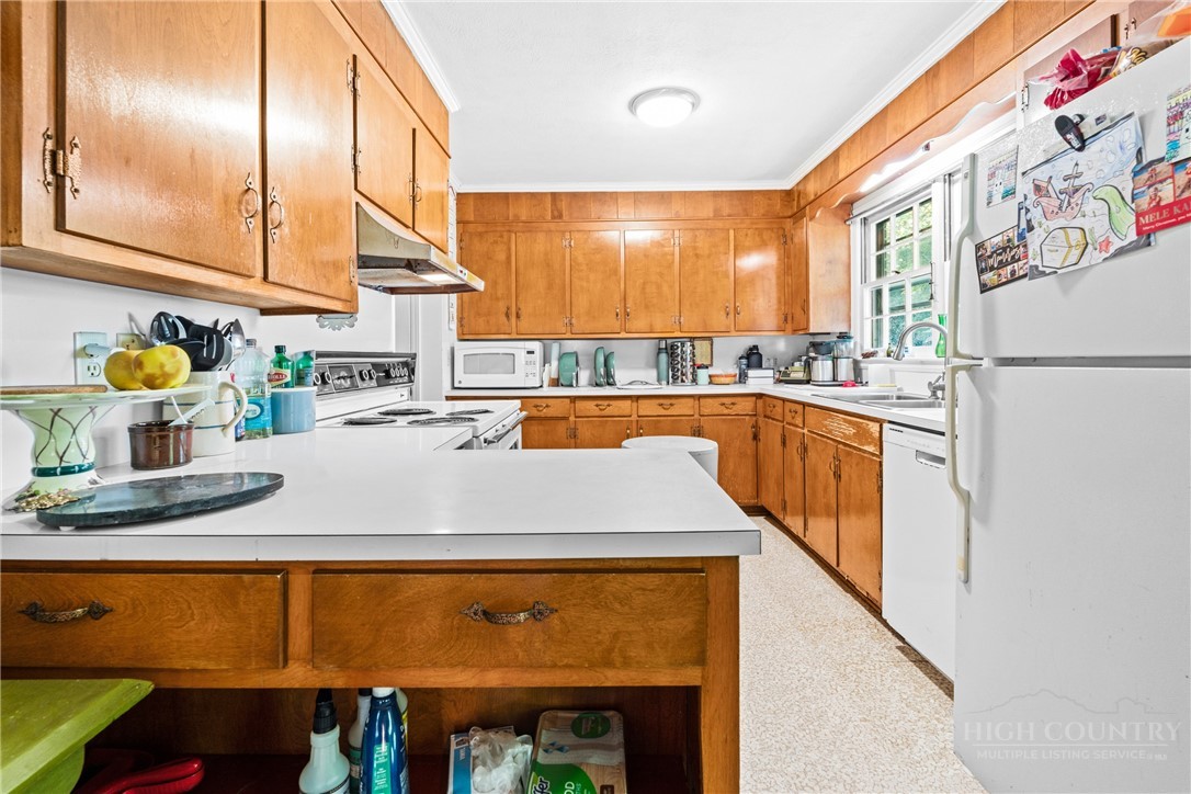 1794 Highway 105 Boone, NC 28607 - Photo 23 of 29 a kitchen with stainless steel appliances granite countertop a sink and a refrigerator