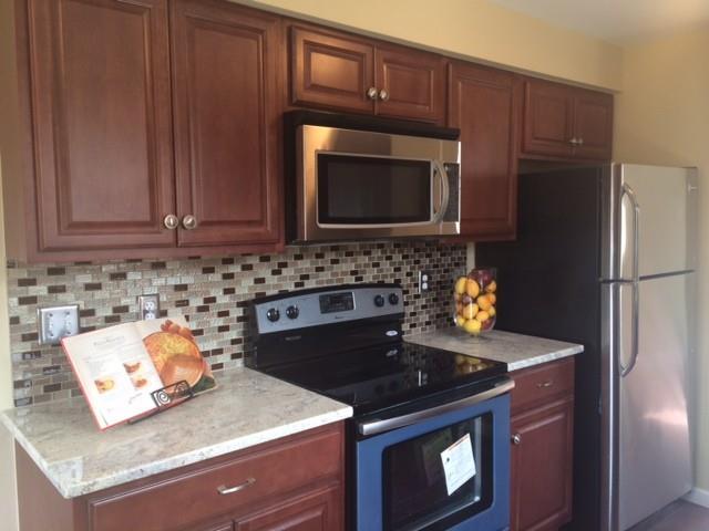 66 River Bend Road, Unit D Stratford, CT 06614 - Photo 1 of 1 a kitchen with granite countertop wooden cabinets and a stove top oven
