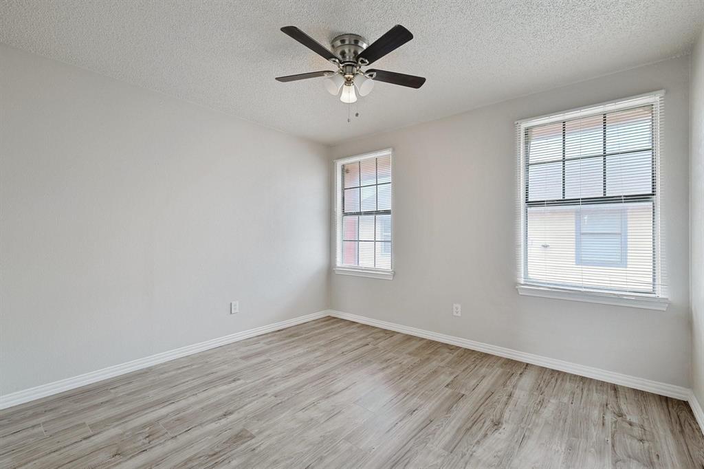 8005 Rothington Road, Unit 1117 Dallas, TX 75227 - Photo 3 of 13 Empty room with plenty of natural light, light wood finished floors, a textured ceiling, and ceiling fan